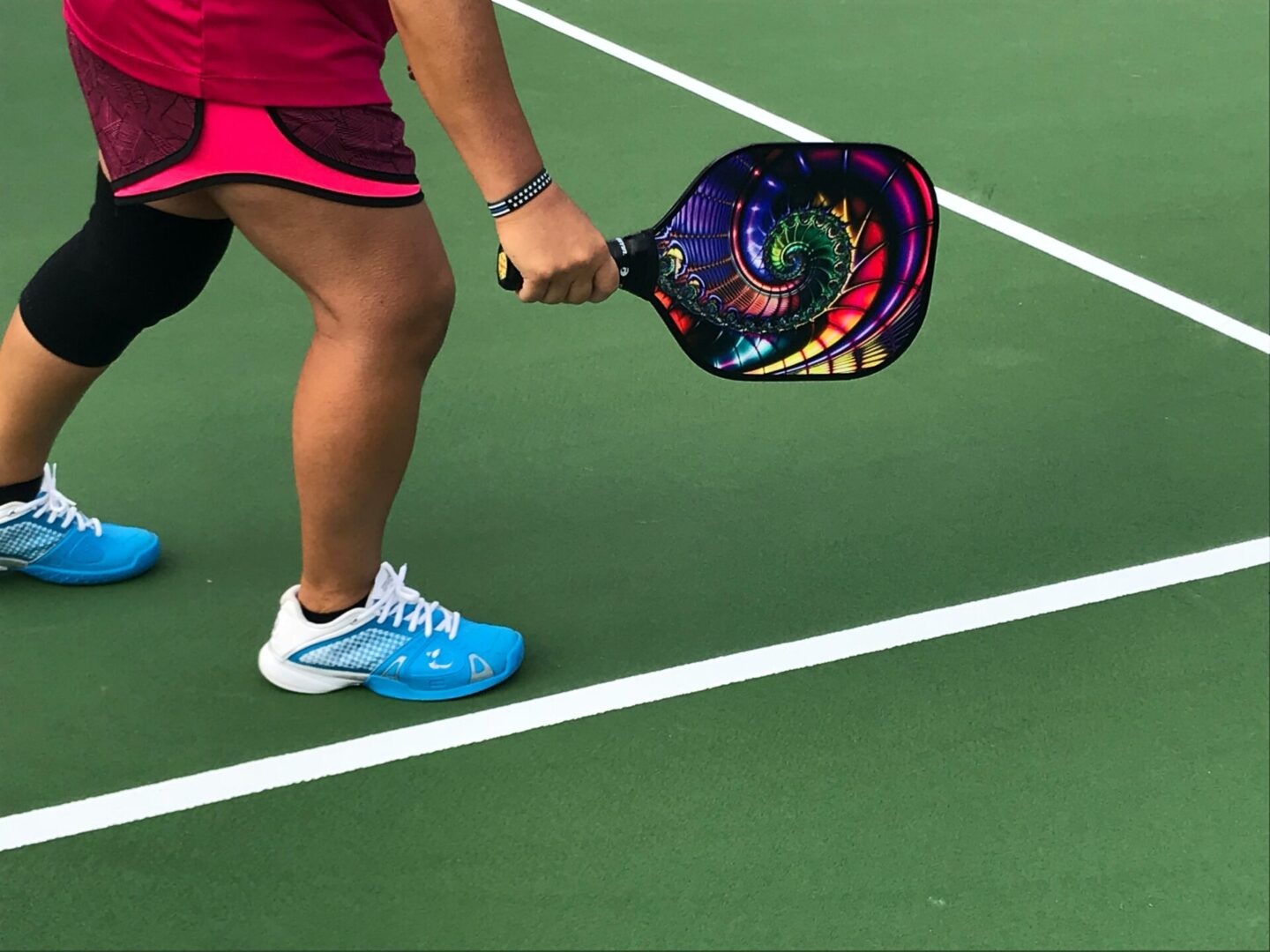 A woman holding a racquet on top of a tennis court.