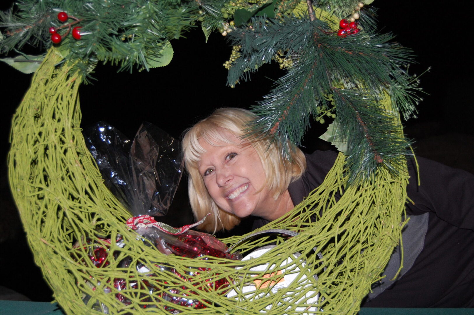 A woman is smiling in a hammock under the christmas tree.